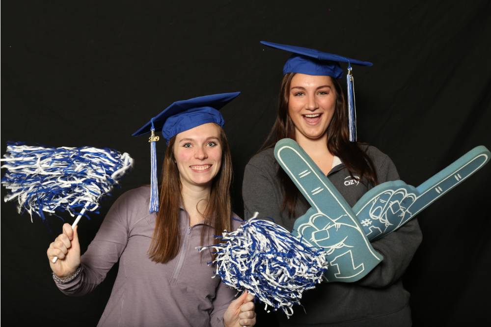 friends posing with foam fingers and pom poms